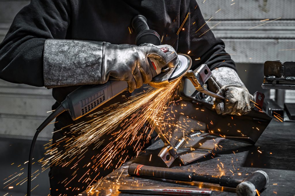 View of worker grinding a piece of metal, France