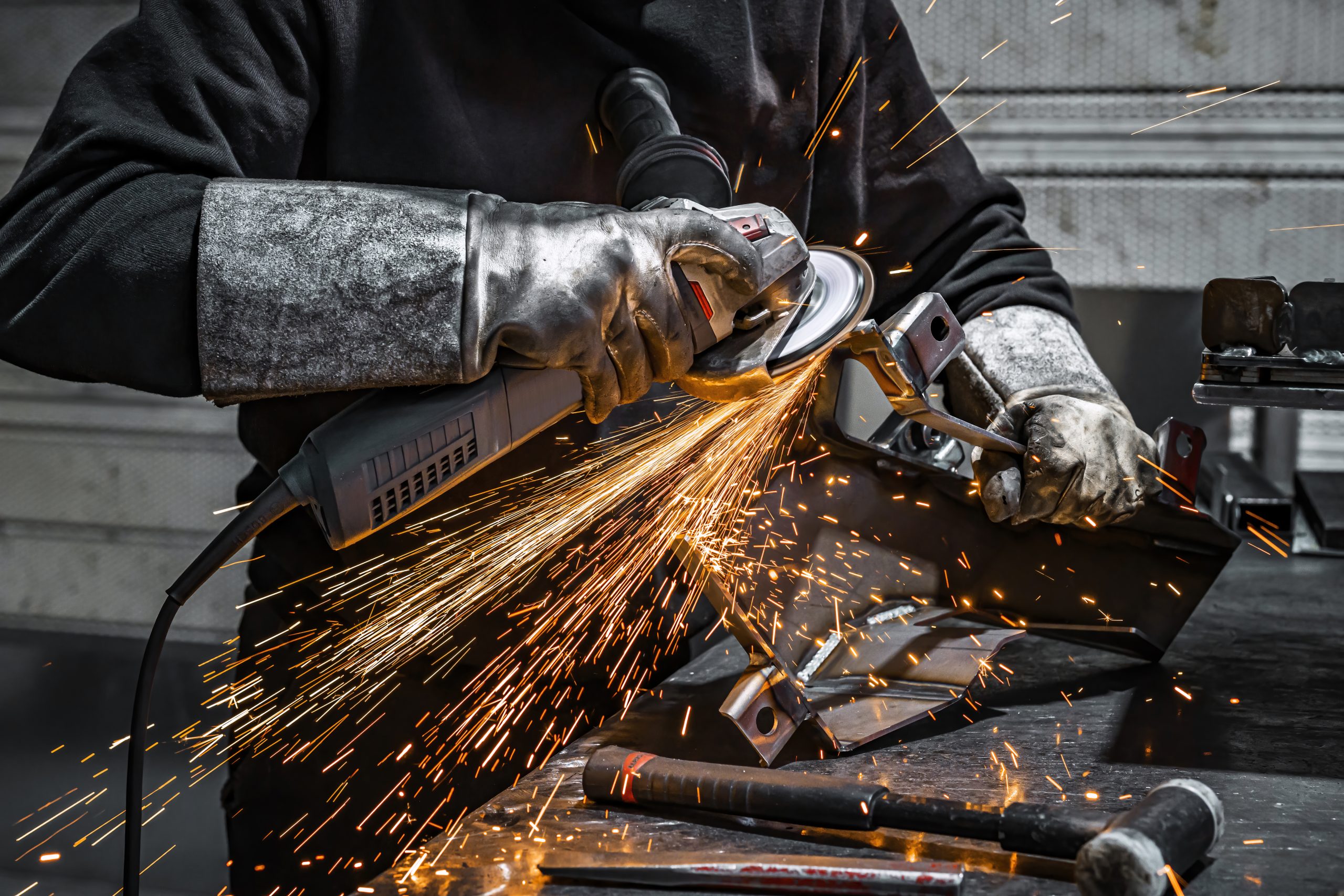 View of worker grinding a piece of metal, France